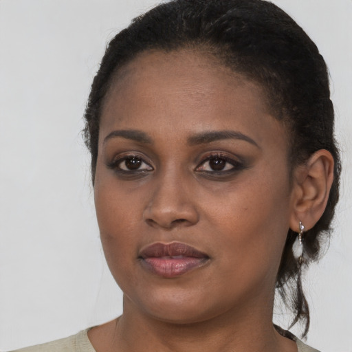 Joyful black young-adult female with short  brown hair and brown eyes