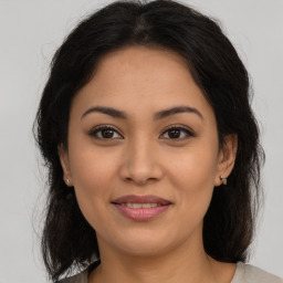 Joyful latino young-adult female with medium  brown hair and brown eyes