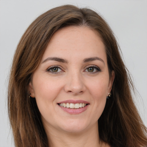 Joyful white young-adult female with long  brown hair and green eyes