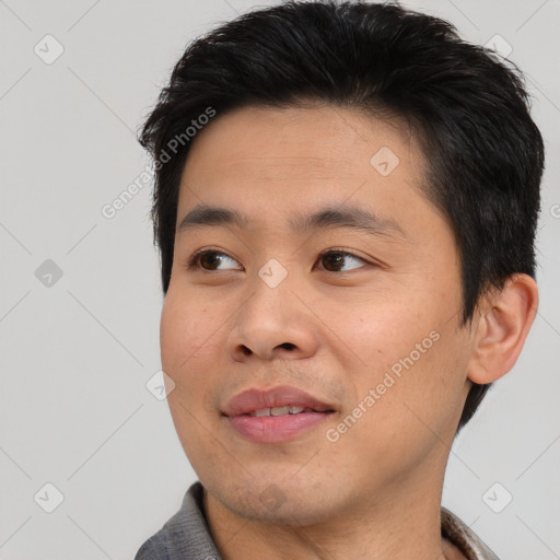 Joyful asian young-adult male with short  black hair and brown eyes