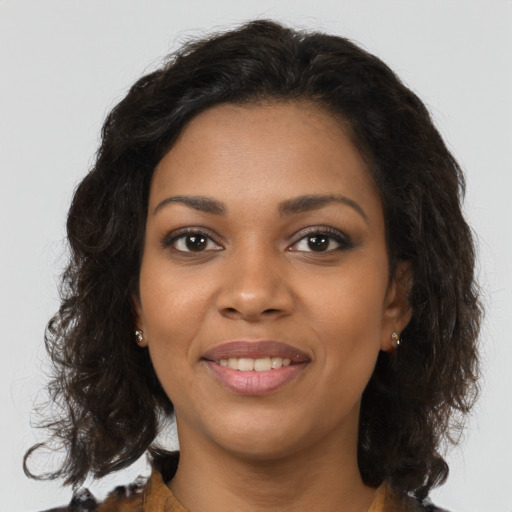 Joyful black young-adult female with long  brown hair and brown eyes