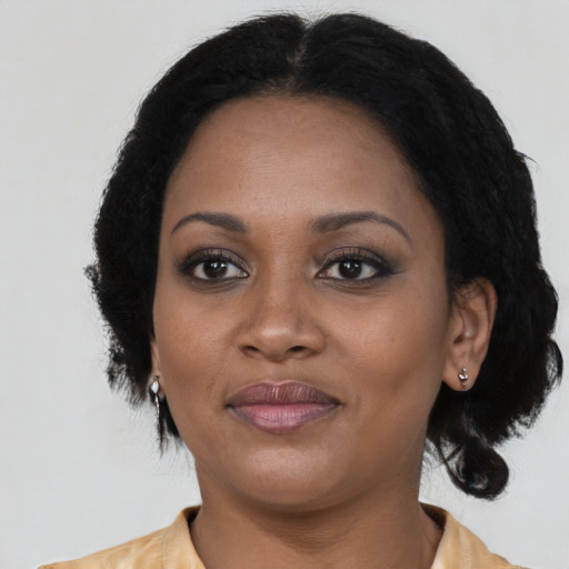 Joyful black adult female with short  black hair and brown eyes