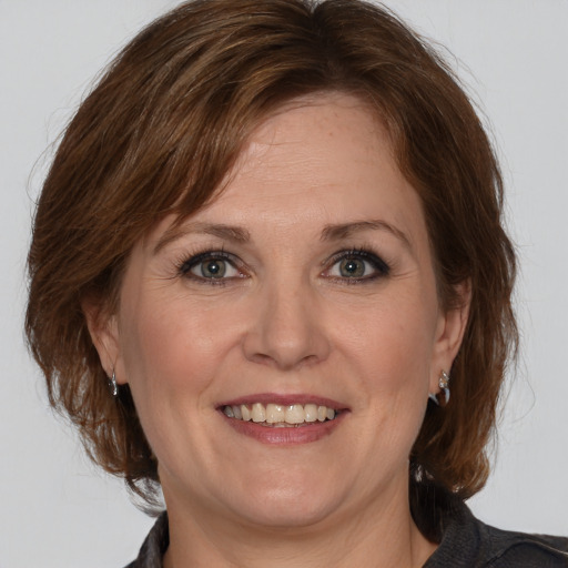 Joyful white adult female with medium  brown hair and grey eyes