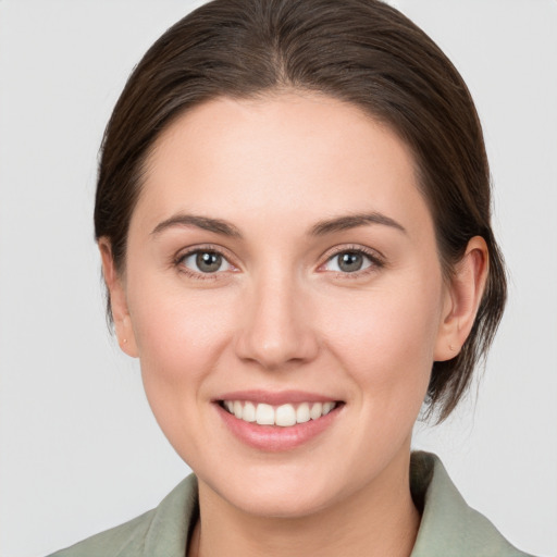 Joyful white young-adult female with medium  brown hair and grey eyes