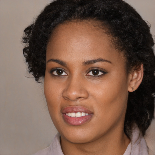 Joyful black young-adult female with medium  black hair and brown eyes