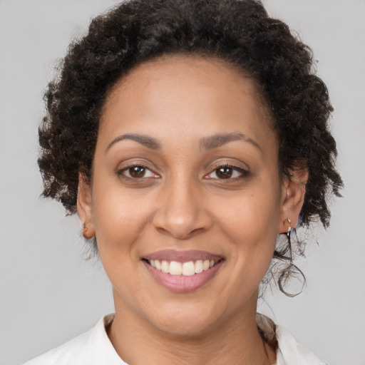 Joyful latino adult female with medium  brown hair and brown eyes