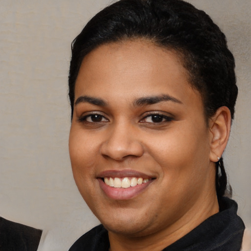 Joyful latino young-adult female with short  black hair and brown eyes