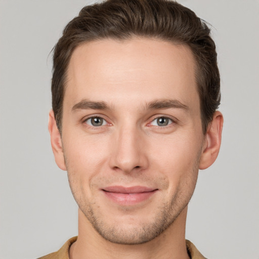 Joyful white young-adult male with short  brown hair and grey eyes