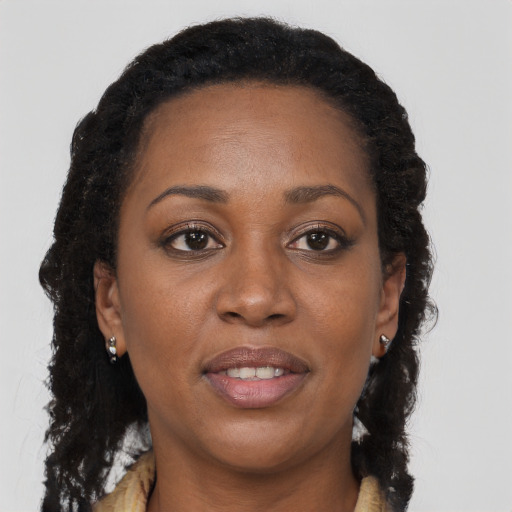 Joyful black young-adult female with long  brown hair and brown eyes