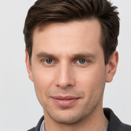 Joyful white young-adult male with short  brown hair and grey eyes