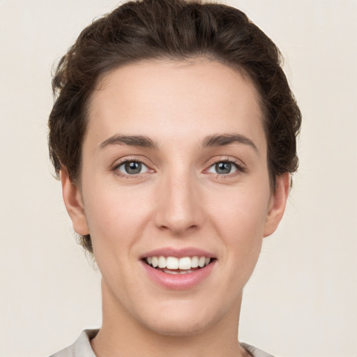 Joyful white young-adult female with short  brown hair and grey eyes