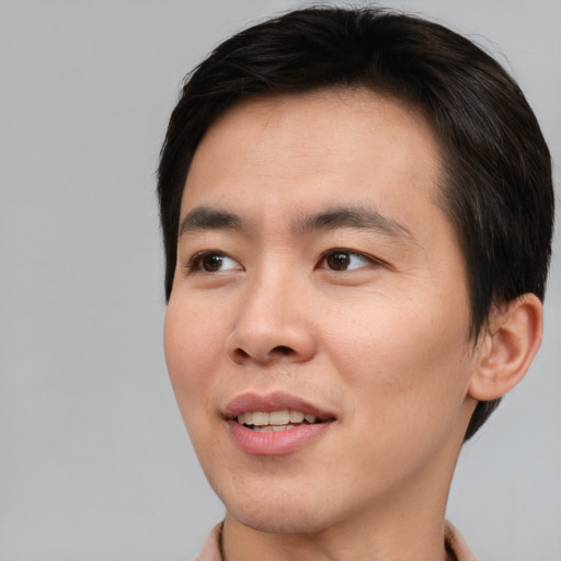 Joyful asian young-adult male with short  brown hair and brown eyes