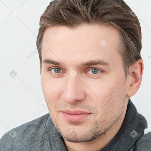 Joyful white young-adult male with short  brown hair and grey eyes