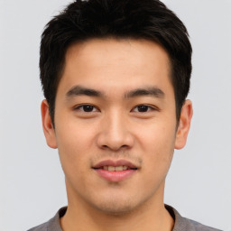 Joyful asian young-adult male with short  brown hair and brown eyes