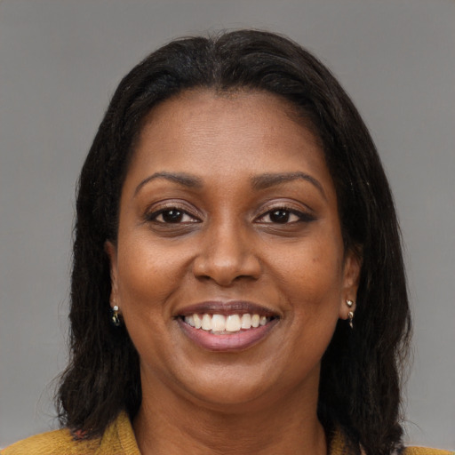 Joyful black young-adult female with long  brown hair and brown eyes