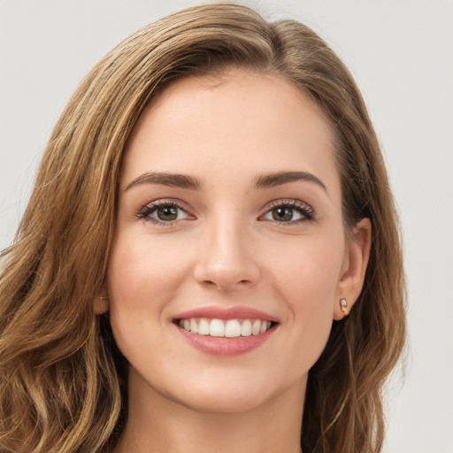 Joyful white young-adult female with long  brown hair and green eyes