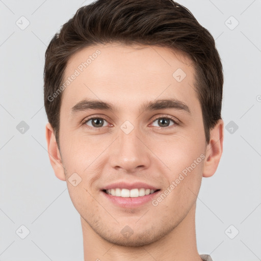 Joyful white young-adult male with short  brown hair and grey eyes