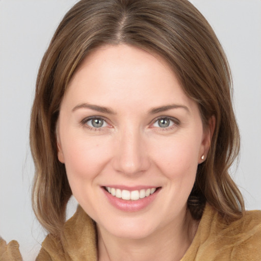 Joyful white young-adult female with medium  brown hair and grey eyes