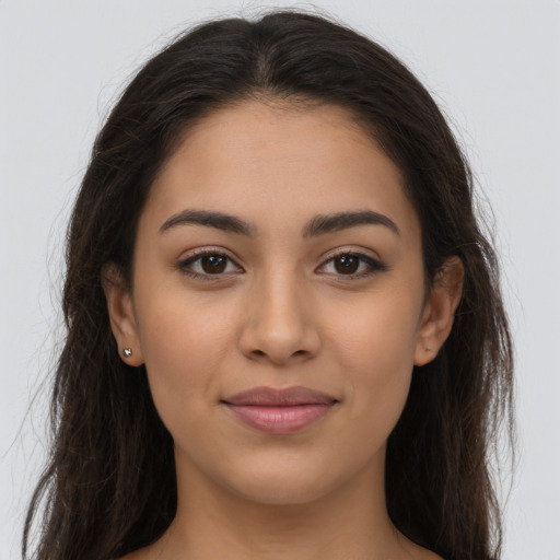 Joyful latino young-adult female with long  brown hair and brown eyes