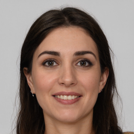 Joyful white young-adult female with long  brown hair and brown eyes