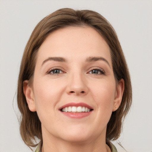 Joyful white young-adult female with medium  brown hair and grey eyes