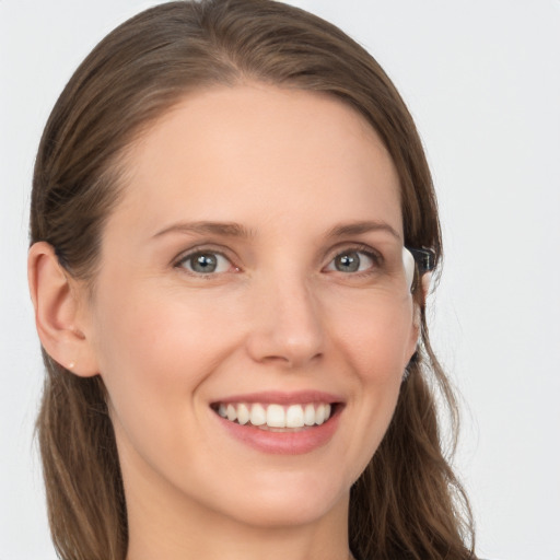 Joyful white young-adult female with long  brown hair and grey eyes