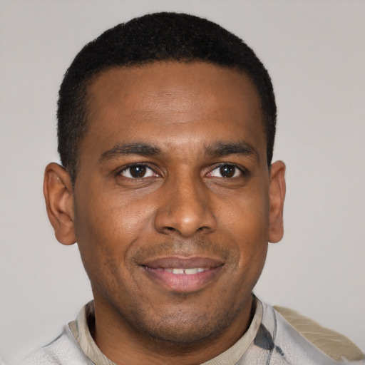 Joyful black young-adult male with short  brown hair and brown eyes