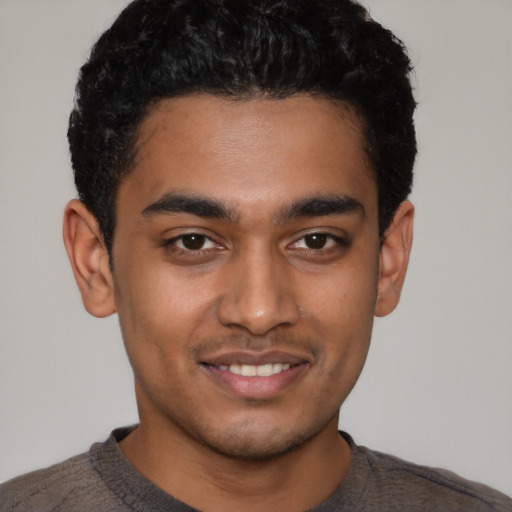 Joyful latino young-adult male with short  black hair and brown eyes