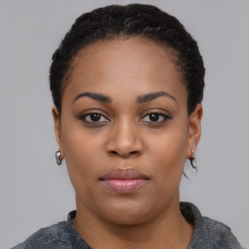 Joyful black young-adult female with short  black hair and brown eyes