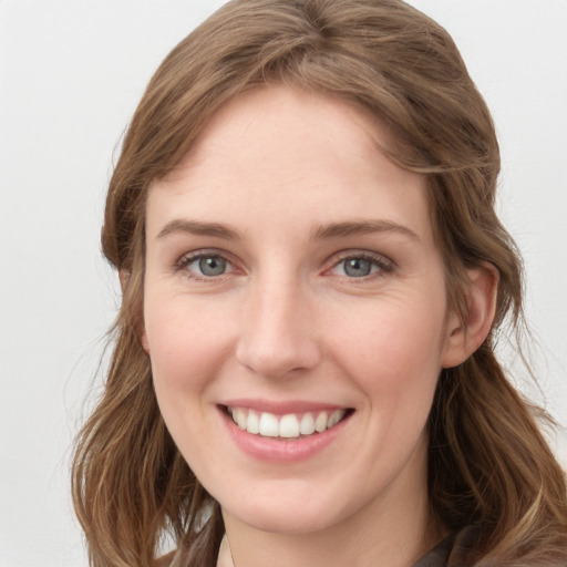 Joyful white young-adult female with long  brown hair and grey eyes