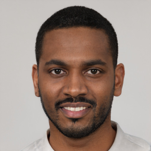 Joyful black young-adult male with short  black hair and brown eyes