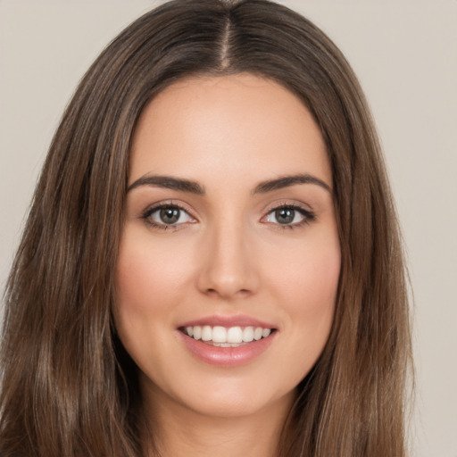 Joyful white young-adult female with long  brown hair and brown eyes