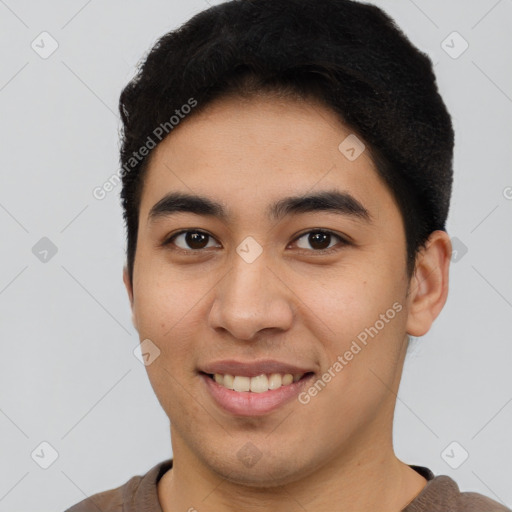 Joyful latino young-adult male with short  black hair and brown eyes