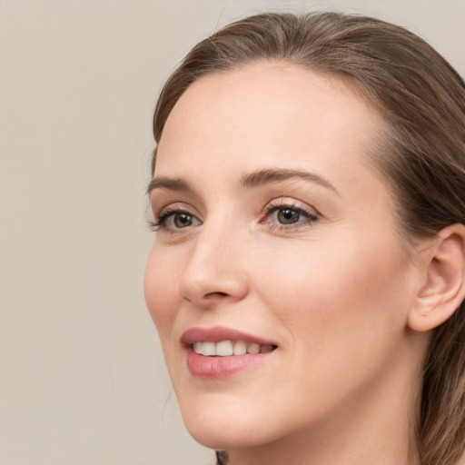 Joyful white young-adult female with long  brown hair and grey eyes