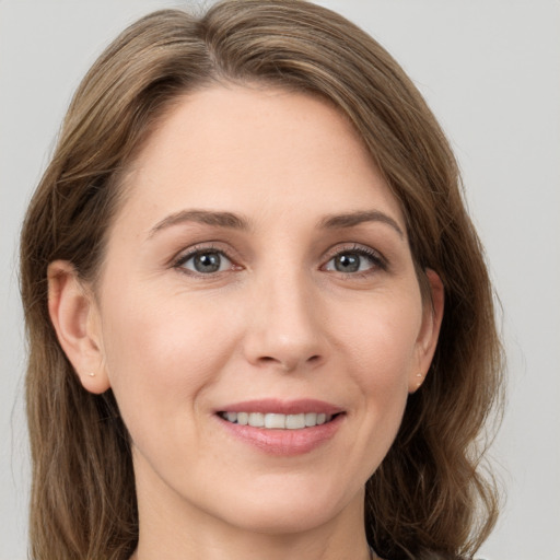 Joyful white young-adult female with medium  brown hair and grey eyes