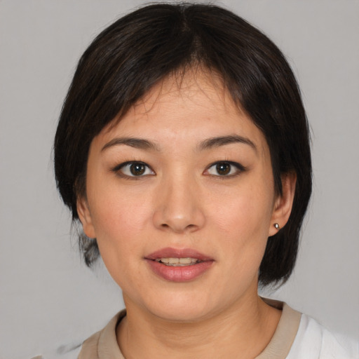 Joyful asian young-adult female with medium  brown hair and brown eyes