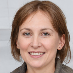 Joyful white adult female with medium  brown hair and grey eyes