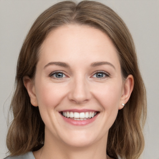 Joyful white young-adult female with medium  brown hair and grey eyes