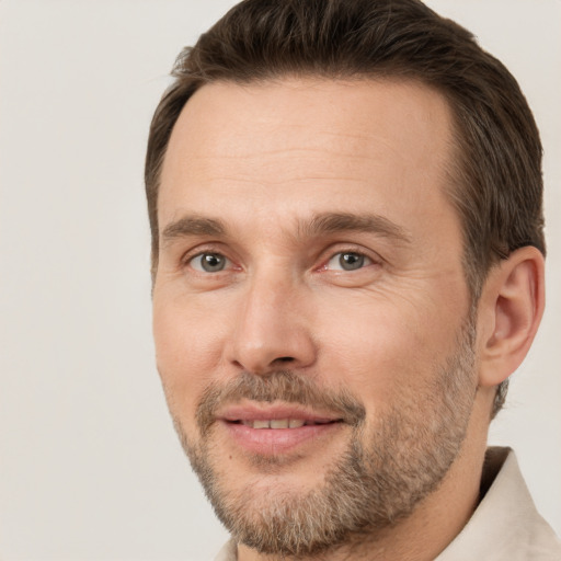 Joyful white adult male with short  brown hair and brown eyes