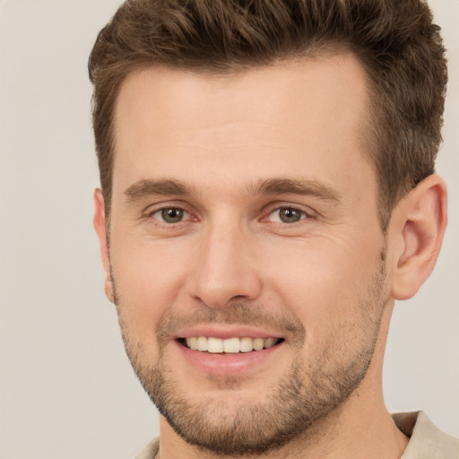 Joyful white young-adult male with short  brown hair and brown eyes