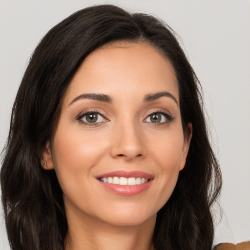 Joyful white young-adult female with long  brown hair and brown eyes