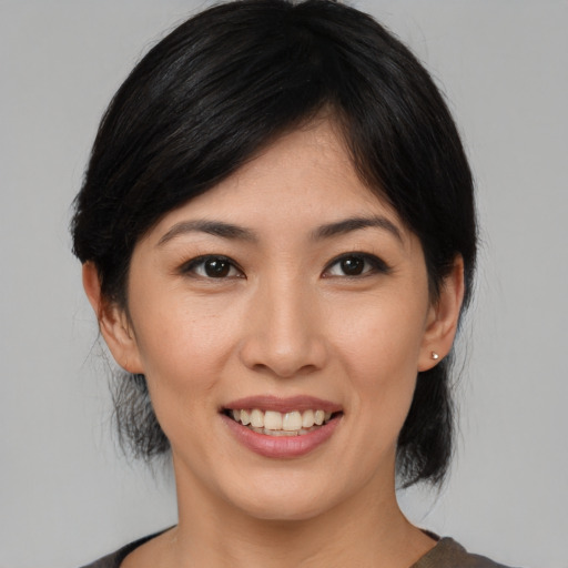 Joyful asian young-adult female with medium  black hair and brown eyes