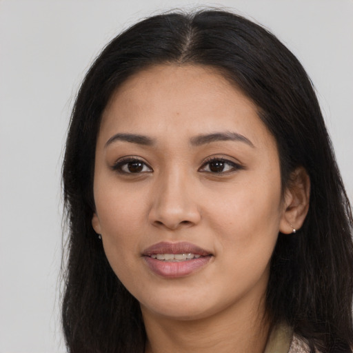 Joyful latino young-adult female with long  brown hair and brown eyes