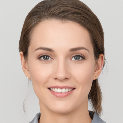 Joyful white young-adult female with medium  brown hair and grey eyes