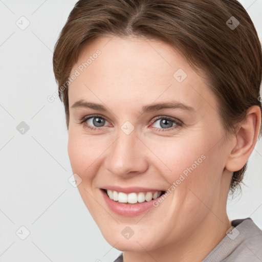 Joyful white young-adult female with short  brown hair and grey eyes