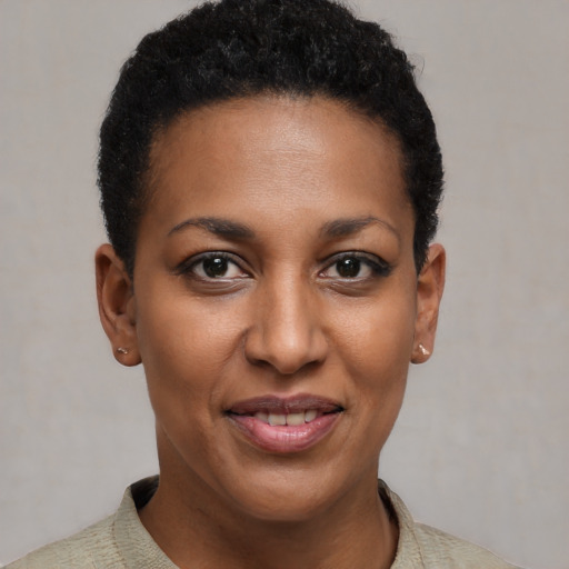 Joyful black young-adult female with short  black hair and brown eyes