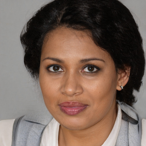 Joyful black young-adult female with medium  brown hair and brown eyes