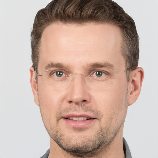 Joyful white adult male with short  brown hair and grey eyes