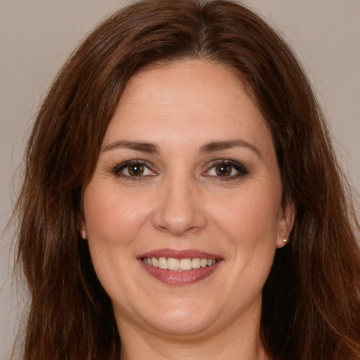 Joyful white adult female with long  brown hair and brown eyes