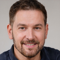 Joyful white adult male with short  brown hair and brown eyes